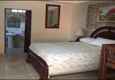 a bedroom with a bed and a bathroom with a sink at Apart-Hotel Costa Verde in Costa Verde