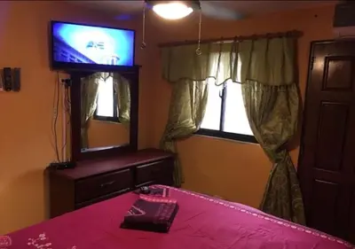 a bedroom with a bed and a tv and a mirror at Apart-Hotel Costa Verde in Costa Verde