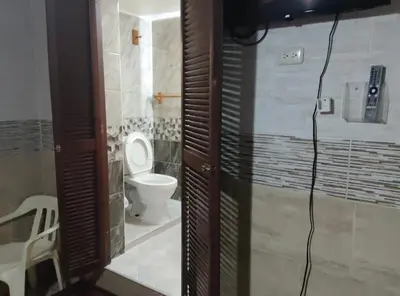 a bathroom with a toilet and a phone on the wall at Apart-Hotel Costa Verde in Costa Verde