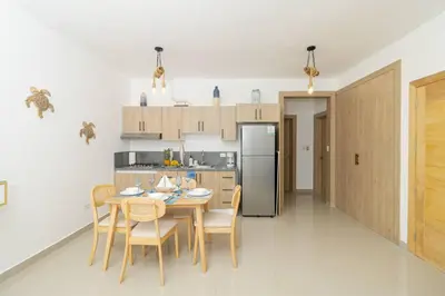a kitchen with a table and chairs and a refrigerator at Chic Bayahibe 2BR in Sunshine near Bayahibe Center in Bayahibe