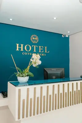 a hotel sign on a wall with a vase of flowers at Hotel cotubanama