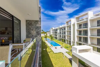 an apartment with a balcony with a swimming pool at 2BR Tropical Escape - Private Terrace, BBQ, Pool, Walk to Beach in Punta Cana