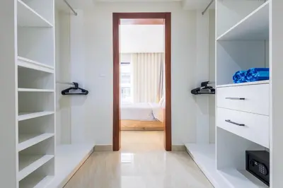 a walk in closet with white shelves and a bedroom at 2BR Tropical Escape - Private Terrace, BBQ, Pool, Walk to Beach in Punta Cana
