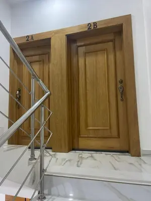 two wooden doors in a room with stairs at res Montesino in San Felipe de Puerto Plata