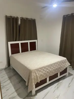 a bedroom with a bed in a room with curtains at res Montesino in San Felipe de Puerto Plata