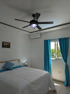 a bedroom with a ceiling fan and a window at Azure Breeze Hotel in Bayahibe