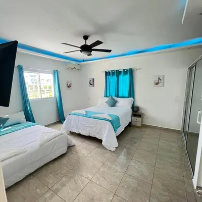 a bedroom with two beds and a ceiling fan at Azure Breeze Hotel in Bayahibe