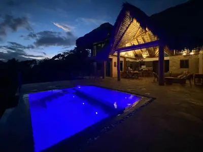 a pool with blue lights in front of a house at AguaSanta, Breeze & Views in Palmarito