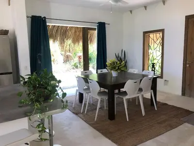 a dining room with a black table and white chairs at Beautiful Caribbean Villa Coson Beach in Las Terrenas