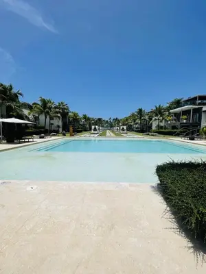 a large swimming pool in a resort with palm trees at Stylish 1BR, Pools & Walk to Beach - Sublime in Las Terrenas