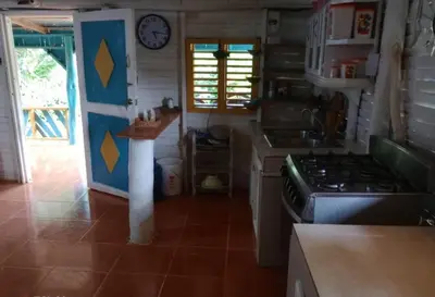 a kitchen with a stove and a clock on the wall at Las Amapolas, Saman typical houses in Las Galeras