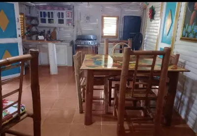 a kitchen with a wooden table and chairs at Las Amapolas, Saman typical houses in Las Galeras