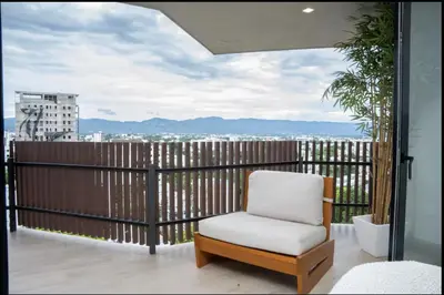 a chair on a balcony with a view of a city at Casita Coco - Luxury Apartment in Santiago in Santiago de los Caballeros
