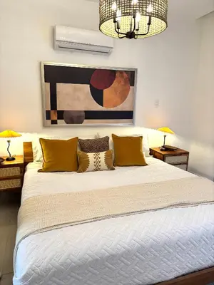 a bedroom with a large bed with yellow pillows at Casita Coco - Luxury Apartment in Santiago in Santiago de los Caballeros