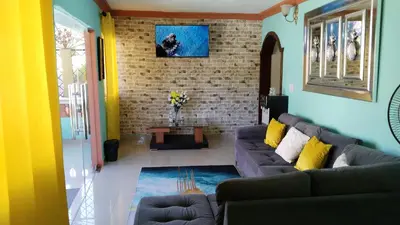a living room with a couch and a brick wall at Doña Nida Family Hotel in Santa Cruz de Barahona