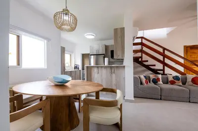 a dining room and living room with a table and a couch at Armonía Las Terrenas in Las Terrenas