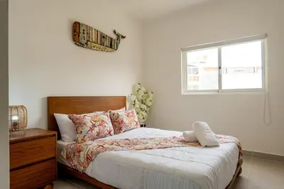 a bedroom with a bed with a window and a window at Armonía Las Terrenas in Las Terrenas