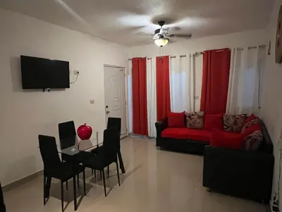 a living room with a red couch and a table at Bienvenue chez soi in Boca Chica