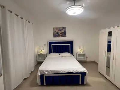 a bedroom with a blue and white bed and two lamps at Bienvenue chez soi in Boca Chica