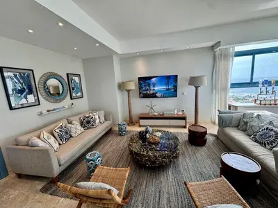 a living room with a couch and a table at Juan dolio Penthouse, beach access 3BR Salitre Tower front of Club Hemingway in Juan Dolio