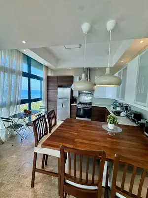 a kitchen and dining room with a wooden table and chairs at Juan dolio Penthouse, beach access 3BR Salitre Tower front of Club Hemingway in Juan Dolio