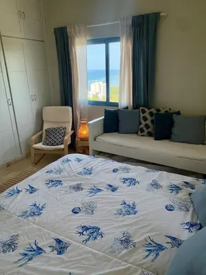 a bedroom with a bed and a couch and a window at Juan dolio Penthouse, beach access 3BR Salitre Tower front of Club Hemingway in Juan Dolio