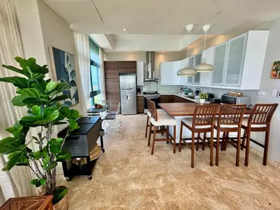a kitchen and dining room with a table and chairs at Juan dolio Penthouse, beach access 3BR Salitre Tower front of Club Hemingway in Juan Dolio