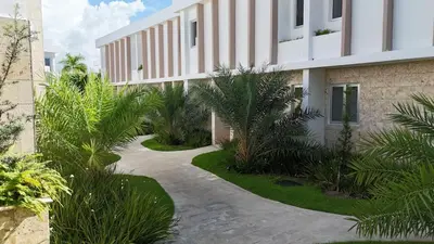 a walkway in front of a building with plants at Villa Padierna, Elegant Beach House Getaway in White Sands in Punta Cana