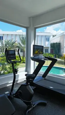 a room with a gym with a treadmill and a laptop at Villa Padierna, Elegant Beach House Getaway in White Sands in Punta Cana