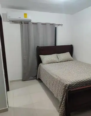 a bedroom with a bed and a window with a curtain at Habitación con baño privado y otras áreas compartidas in San Luis
