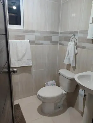 a bathroom with a white toilet and a sink at Habitación con baño privado y otras áreas compartidas in San Luis