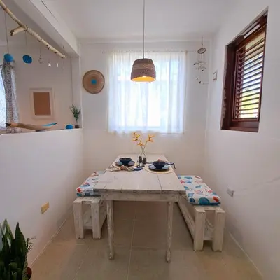 a dining room with a wooden table in a room at Beach Bungalow 100 m Playa Coson in Las Terrenas