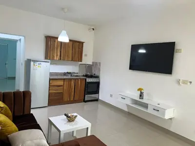 a living room with a couch and a tv on the wall at Paisible et confo in Boca Chica