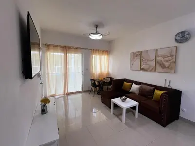 a living room with a couch and a table at Paisible et confo in Boca Chica