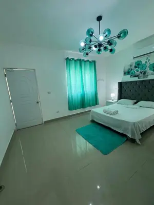 a bedroom with a bed and a chandelier at Paisible et confo in Boca Chica