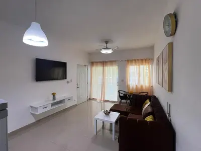 a living room with a couch and a tv at Paisible et confo in Boca Chica