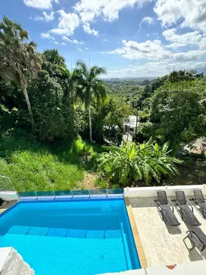 a pool with chairs and a view of the jungle at Casa Jobo Scenic ViewsPrivate Pool TablePool in San Felipe de Puerto Plata