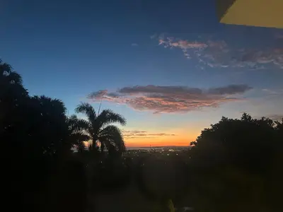 a sunset with a palm tree in the foreground at Casa Jobo Scenic ViewsPrivate Pool TablePool in San Felipe de Puerto Plata