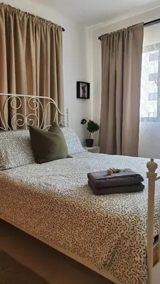 a bed in a bedroom with curtains and a bed sidx sidx sidx at Backup Power 2BR 2BA AC WiFi Gym 24h Security Ideal for long stays in Santiago de los Caballeros