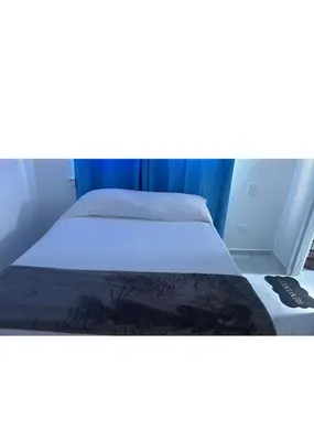 a bed in a room with a white mattress at Casi de Aleyda in Las Terrenas