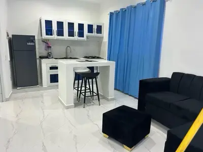 a kitchen and living room with a couch and a table at Casi de Aleyda in Las Terrenas