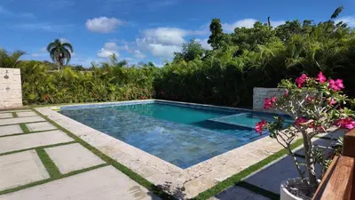 a swimming pool in a yard with flowers at Villa Dulce Refugio in Cabrera