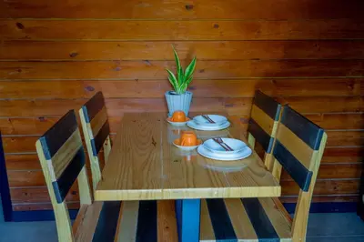 a wooden table with two chairs and a plant on it at Villa Dulce Refugio in Cabrera