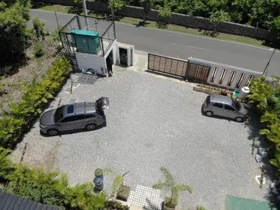 two cars parked in a parking lot next to a road at Villa Dulce Refugio in Cabrera