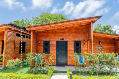 a log cabin with blue chairs in front of it at Villa Dulce Refugio in Cabrera