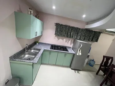 a small kitchen with green cabinets and a sink at Villa las Terrazas in Cabayona