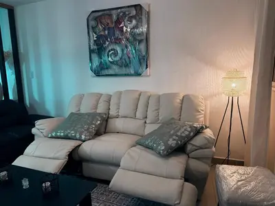 a living room with a white couch and a lamp at Mi casa es tu casa in Santo Domingo