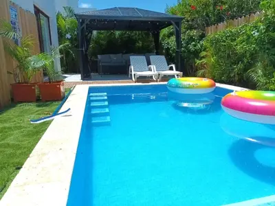 a swimming pool with a pool noodle game in a backyard at Hermosa villa con piscina privada, jacuzzi y playas cercanas in Punta Cana