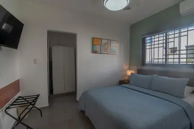 a bedroom with a blue bed and a window at Hermosa villa con piscina privada, jacuzzi y playas cercanas in Punta Cana