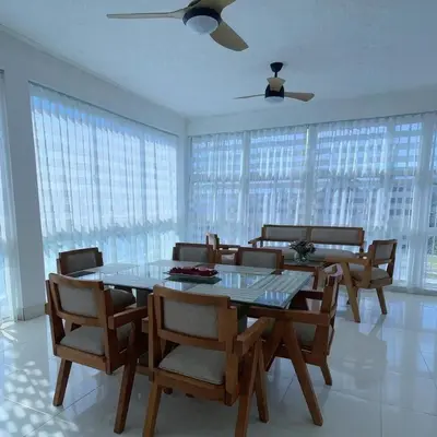 a dining room with a table and chairs and windows at Mar, Sol y Arena in Paraíso